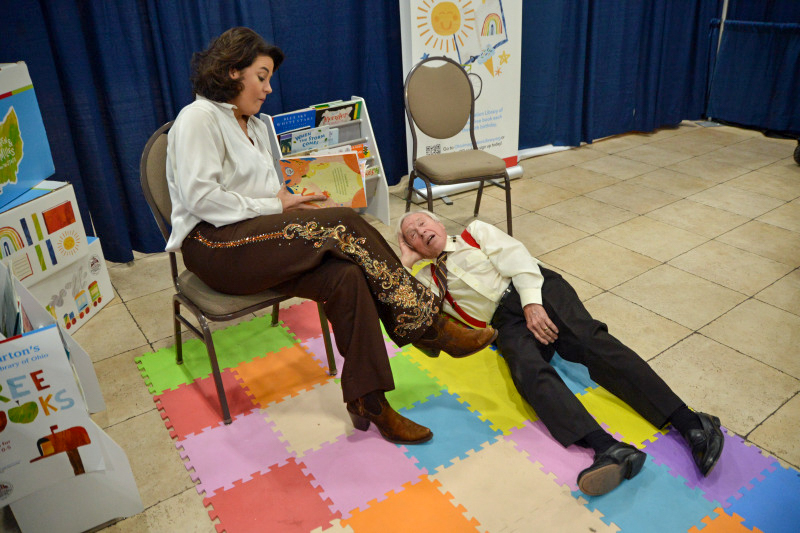 Lizzy Long reads to Little Roy at the November 2025 Industrial Strength Bluegrass Festival - photo © Bill Warren