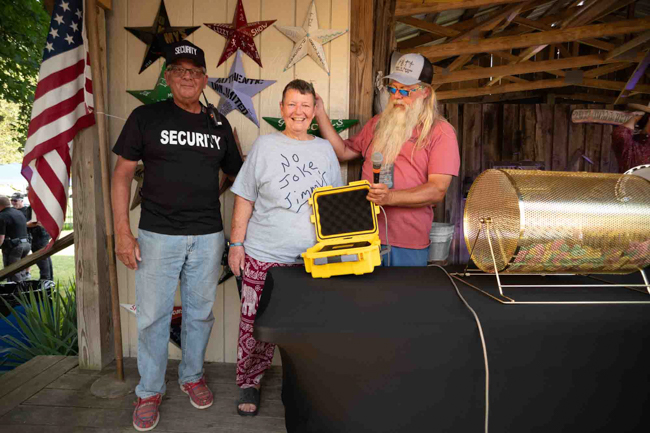 Beverly Conrad (center) wins a lifetime Golden Ticket to Pickin' in Parsons from promoter John Bowers (right) - photo © Jeromie Stephens